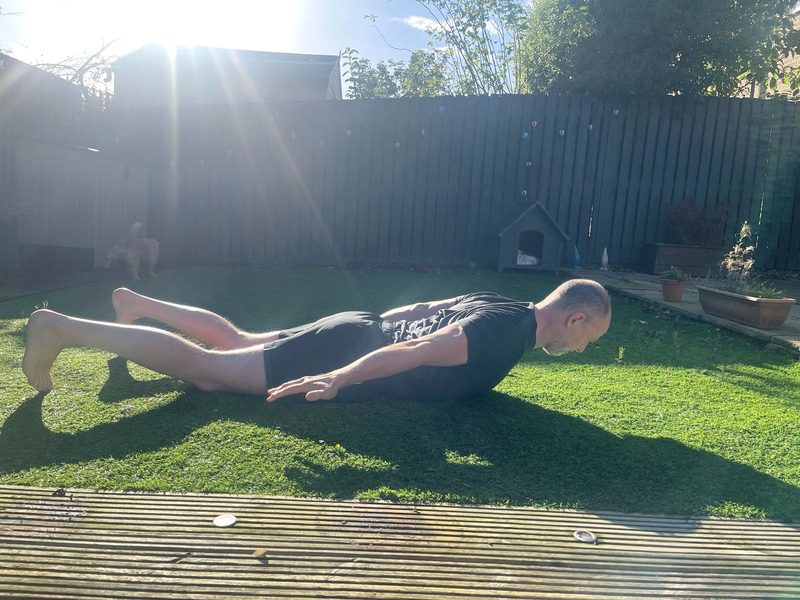 Stephen lying face down with chest lifted and arms by his sides, thumbs turned out